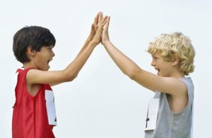 side profile of two boys giving high-five